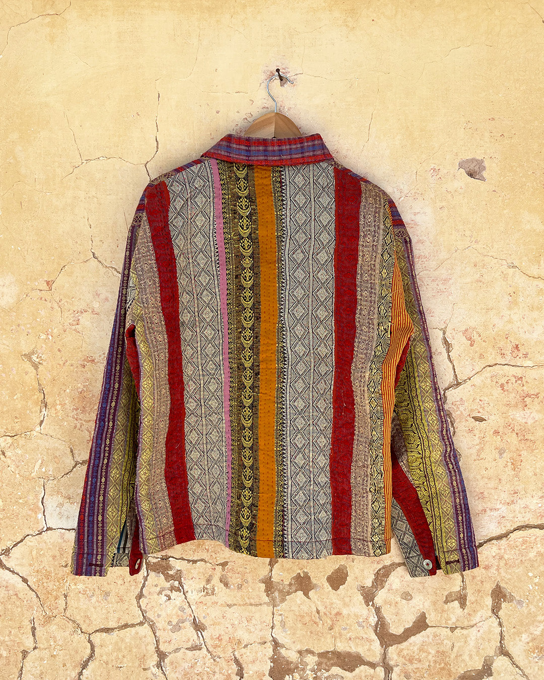 Colorful patterned shirt on a hanger against a textured beige wall DAY-AND-AGE-REX-JACKET-TWO-EXTRA-LIVES