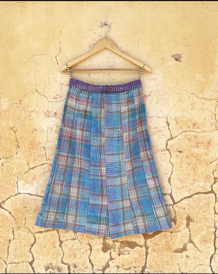 Glacier Plaid skirt by Day and age on a hanger against a textured beige wall  by two extra lives 