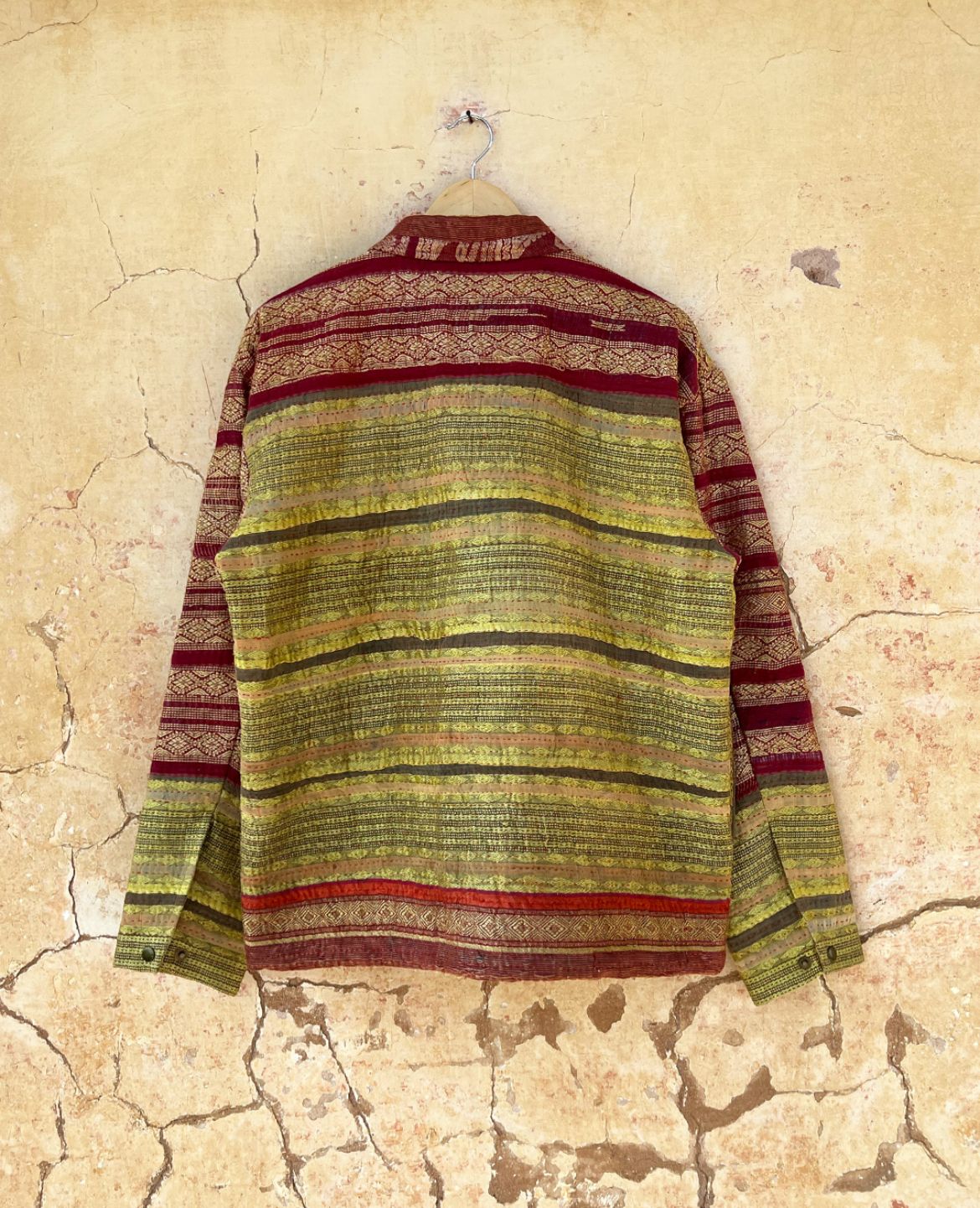 Striped shirt with red and green pattern by day and age on a textured beige background by two extra lives