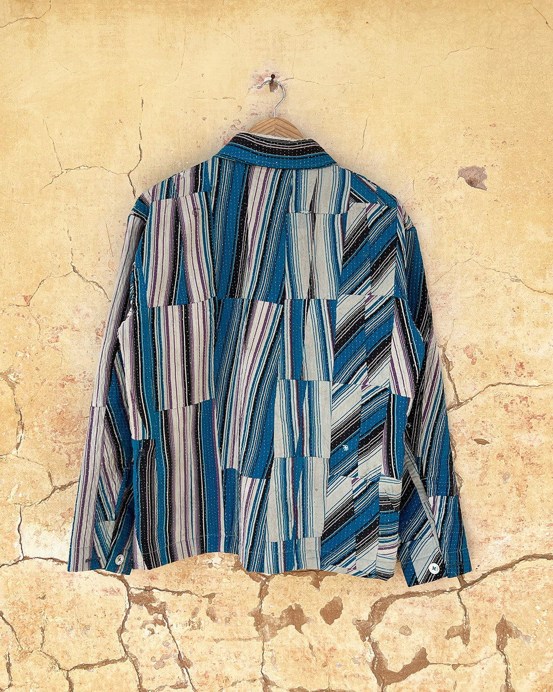 Day and age a blue and gray striped shirt on a textured beige background by two extra lives