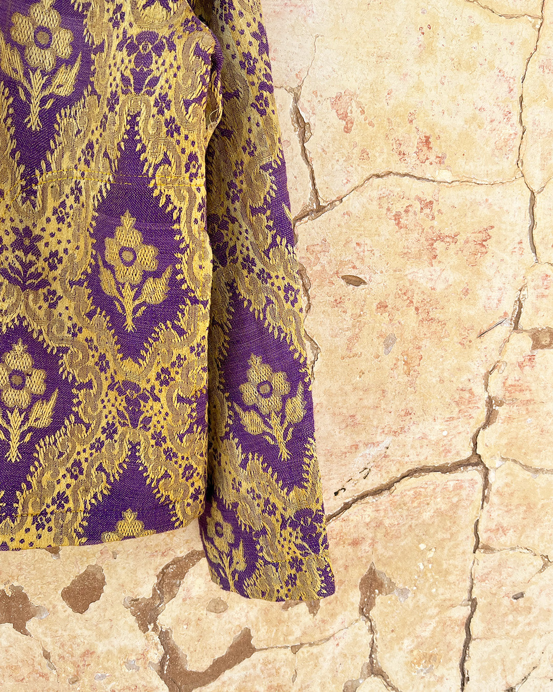 Patterned shirt jacket by day and age on a hanger against a textured wall by two extra lives