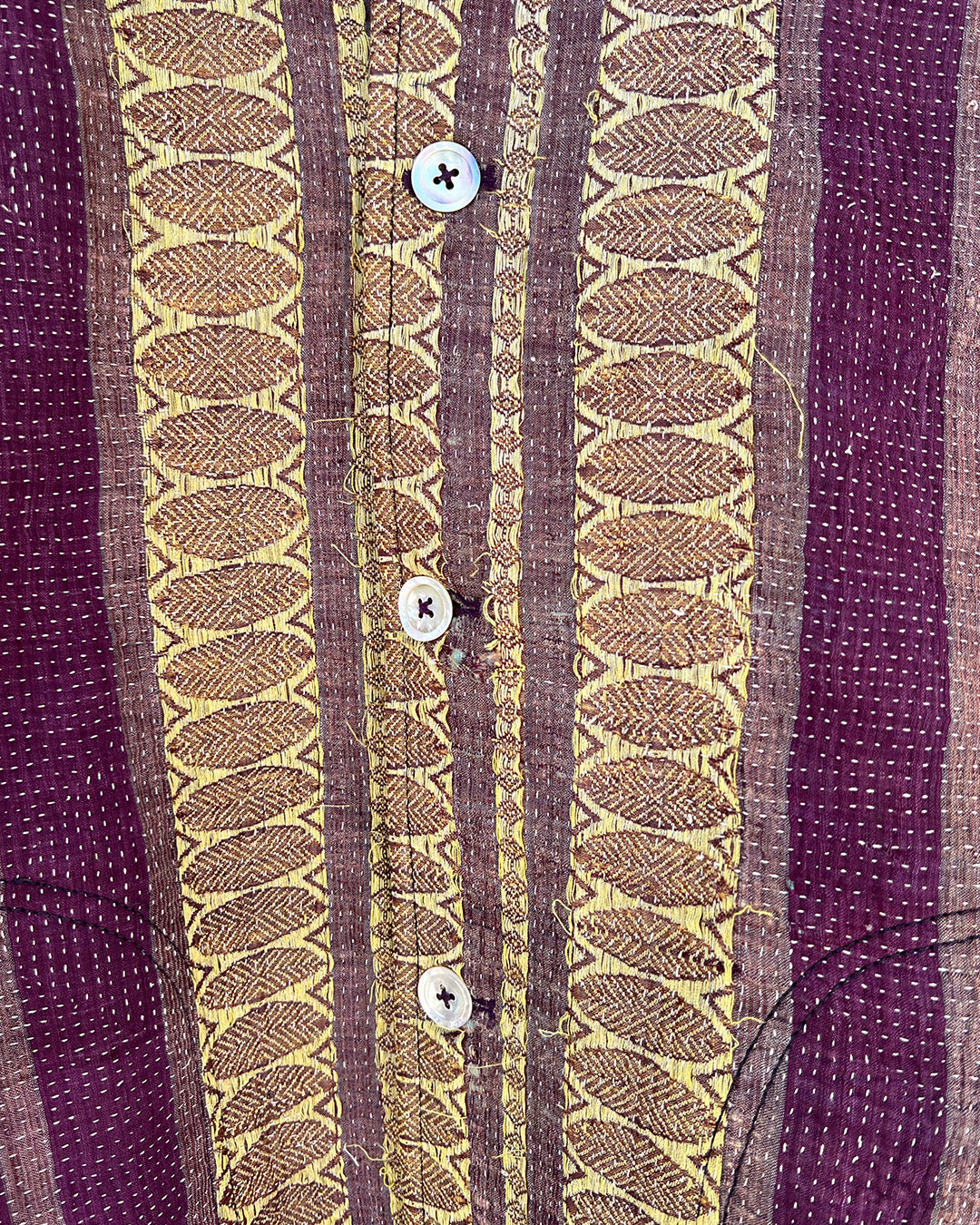 Close-up of a patterned fabric with vertical stripes and button details. Day-and-age-regal-jacket-two-extra-lives