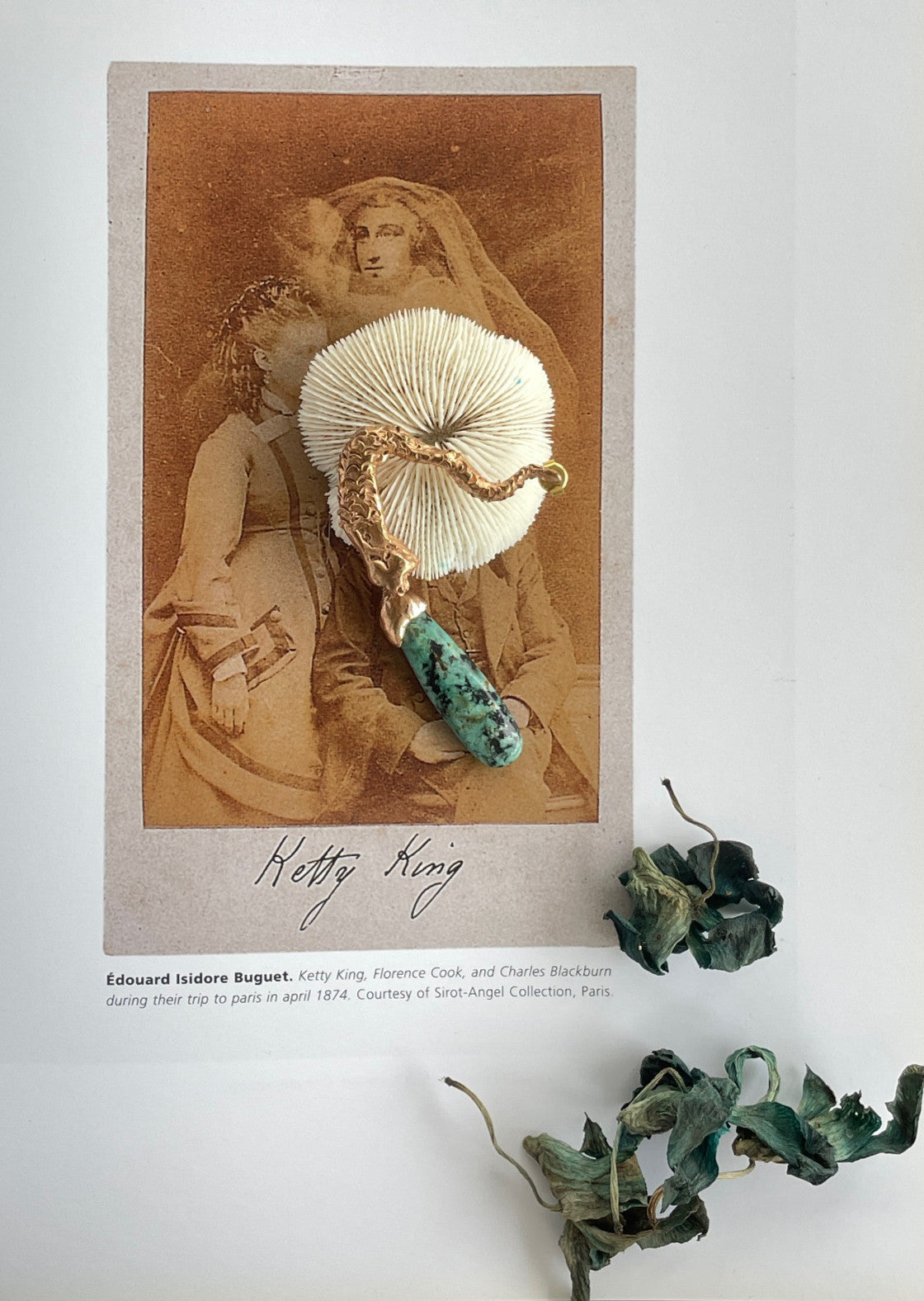 A single gold-colored mermaid earring with a turquoise pendant, displayed on a faded background with written text. Ex Nihilo - Mermaid Singular Earring sold by two extra lives
