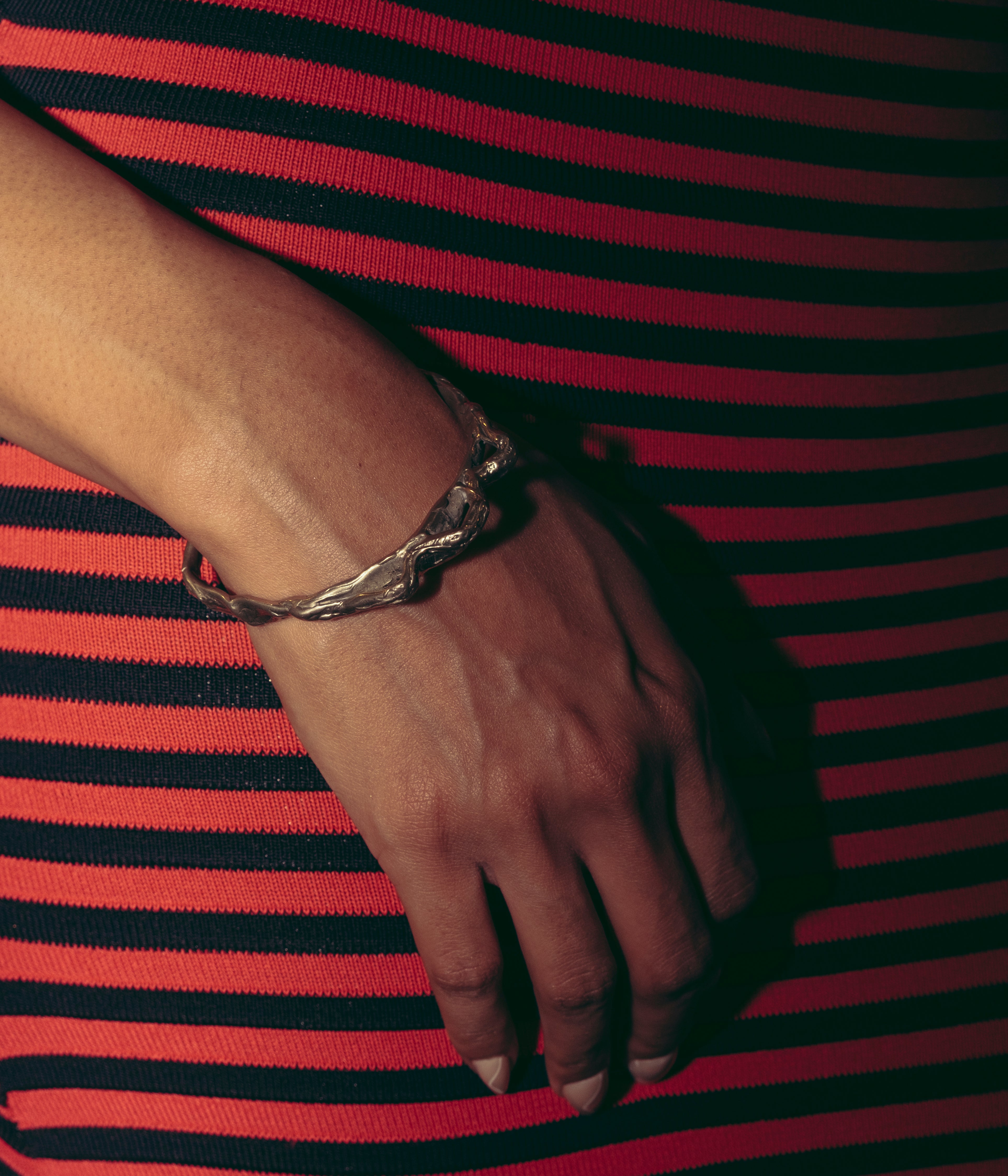 A person's wrist wearing a white rhodium-plated bronze bracelet with a sleek, modern design. 
Ex Nihilo - Mountain Bracelet sold by two extra lives