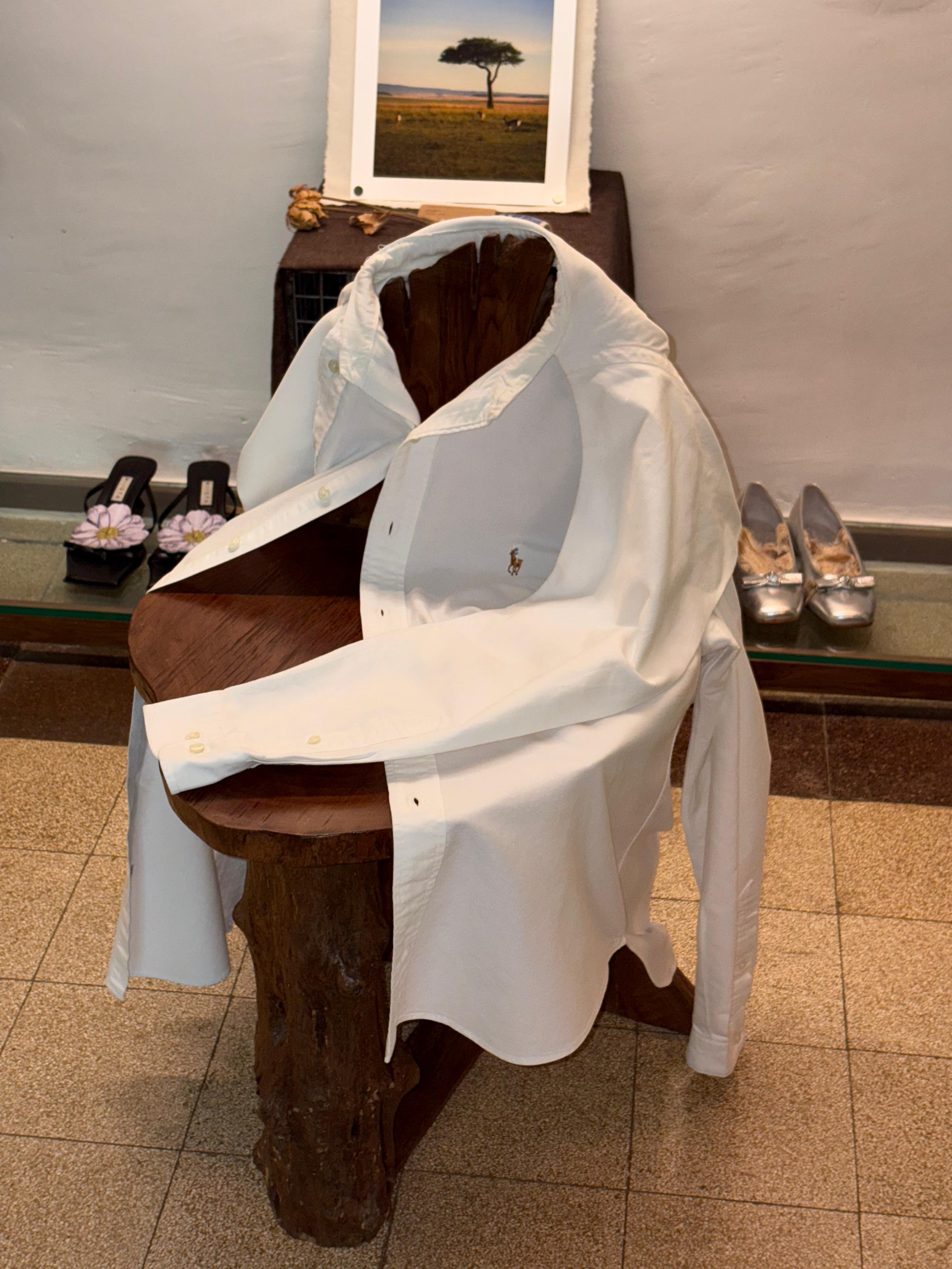 White shirt draped over a wooden chair with shoes and a framed picture in the background. From The Mind - Ralph Lauren Upcycled Shirt With A Hood From The Mind - Ralph Lauren Upcycled Shirt With A Hood From The Mind - Ralph Lauren Upcycled Shirt With A Hood-TWO-EXTRA-LIVES-1