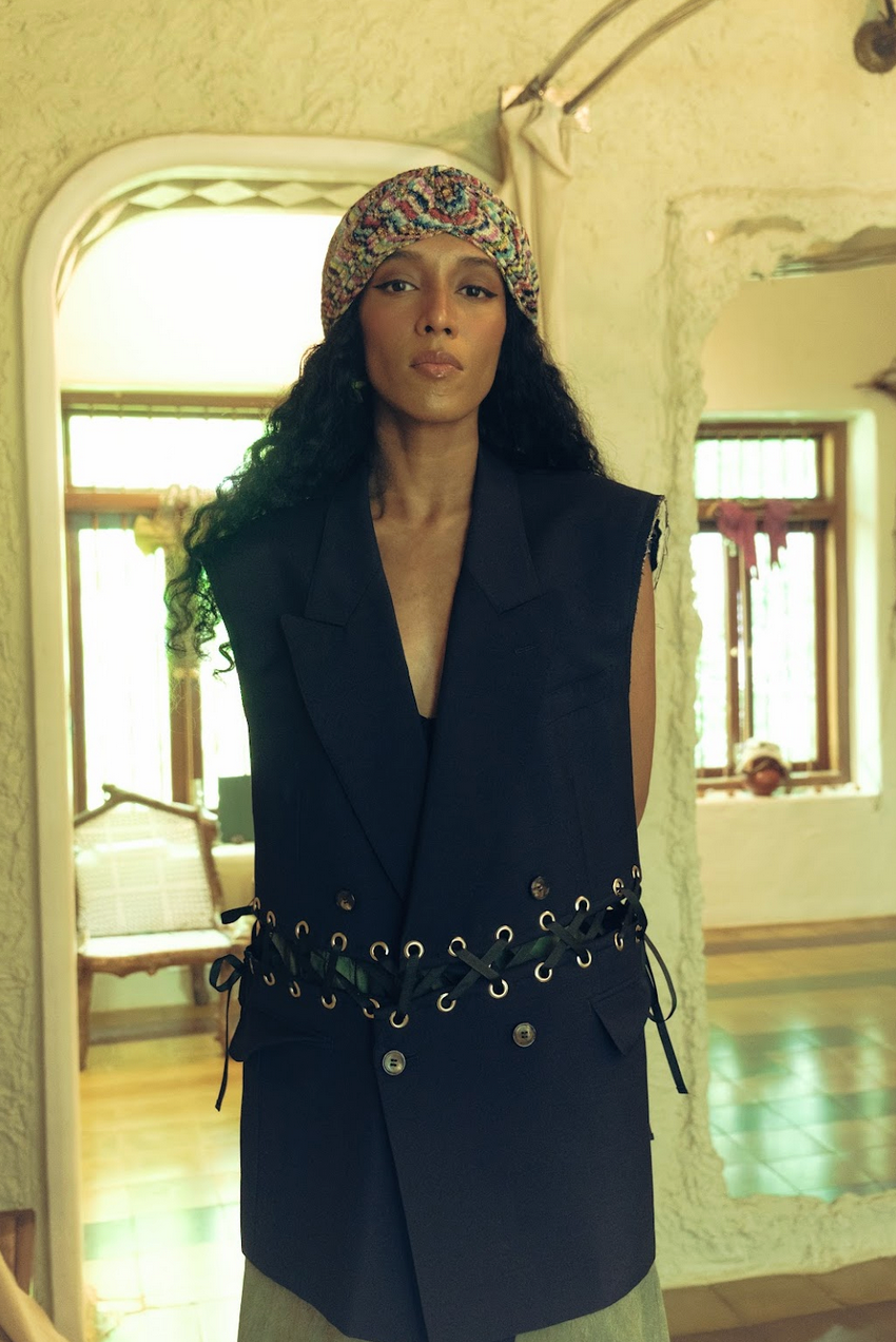 Person wearing a dark blue vest with a unique belt design in an indoor setting. 
Not Conventional - Knot Vest sold by two extra lives