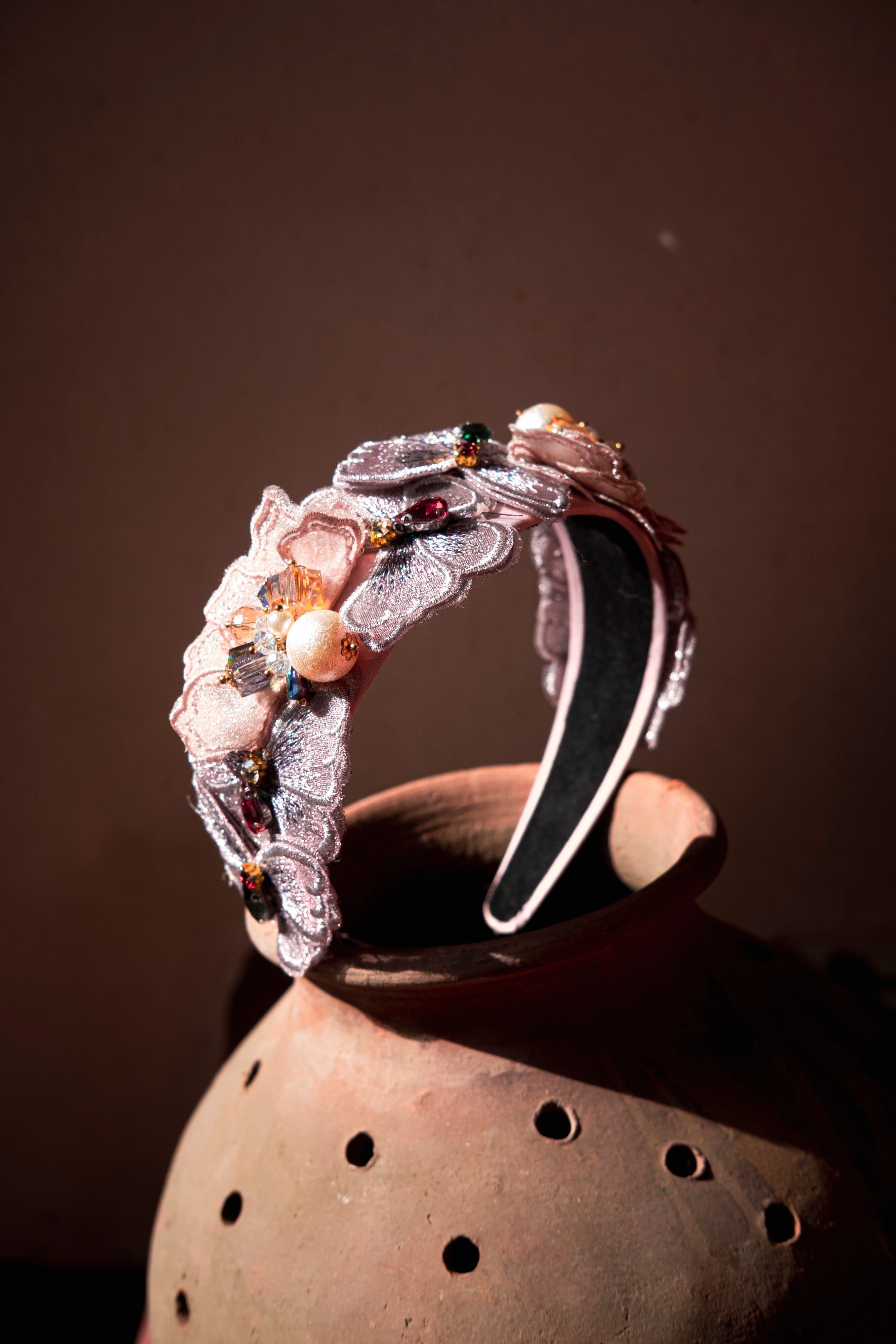 An ornate vintage pink headband with floral patterns and embellishments.