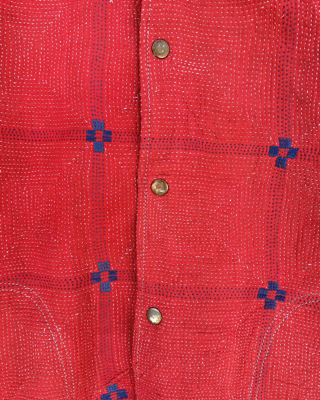 Close-up of a red fabric with blue geometric patterns and metal buttons. day-and-age-steaam-angine-jacket-two-extra-lives